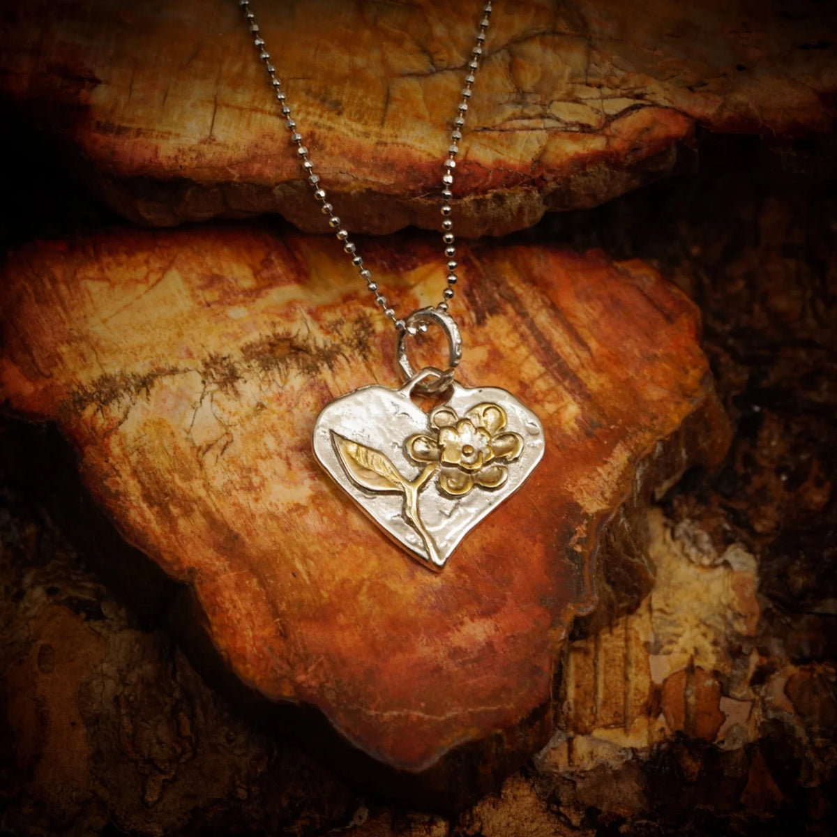 Talisman pentru iubire și căldură sufletească – pandantiv Inimă cu floare, realizat manual din argint 925 cu accente de culoarea aurului, în stil boho și rustic | Art Diva